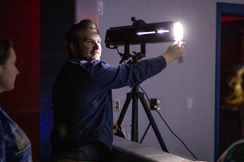 A teacher uses a stage light